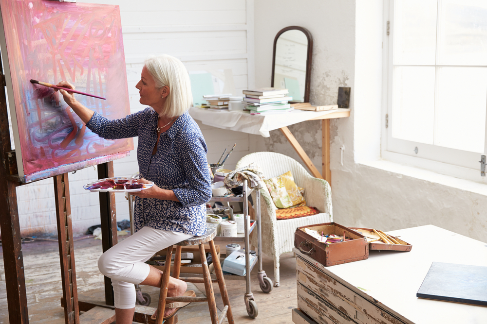 blond lady painting on a canvas