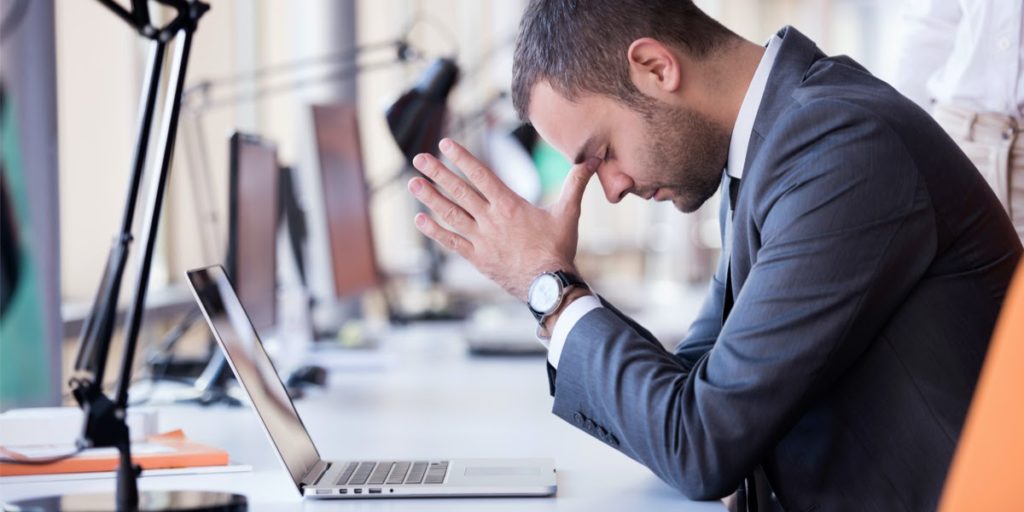upset man in front of a laptop