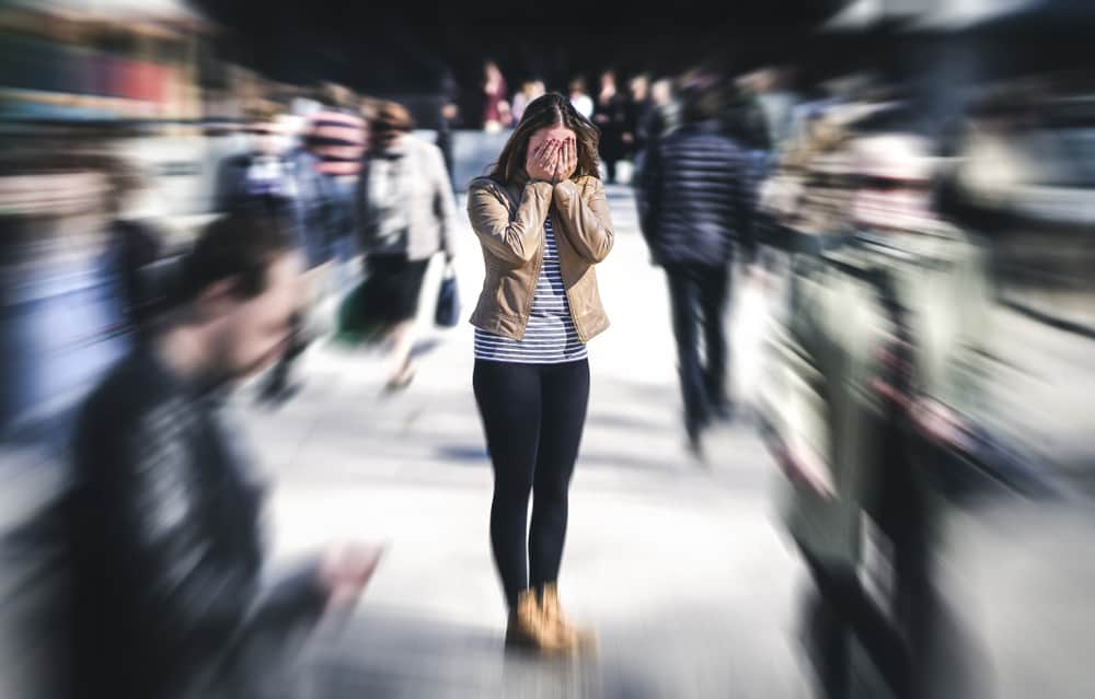 woman in a crowd covering her face