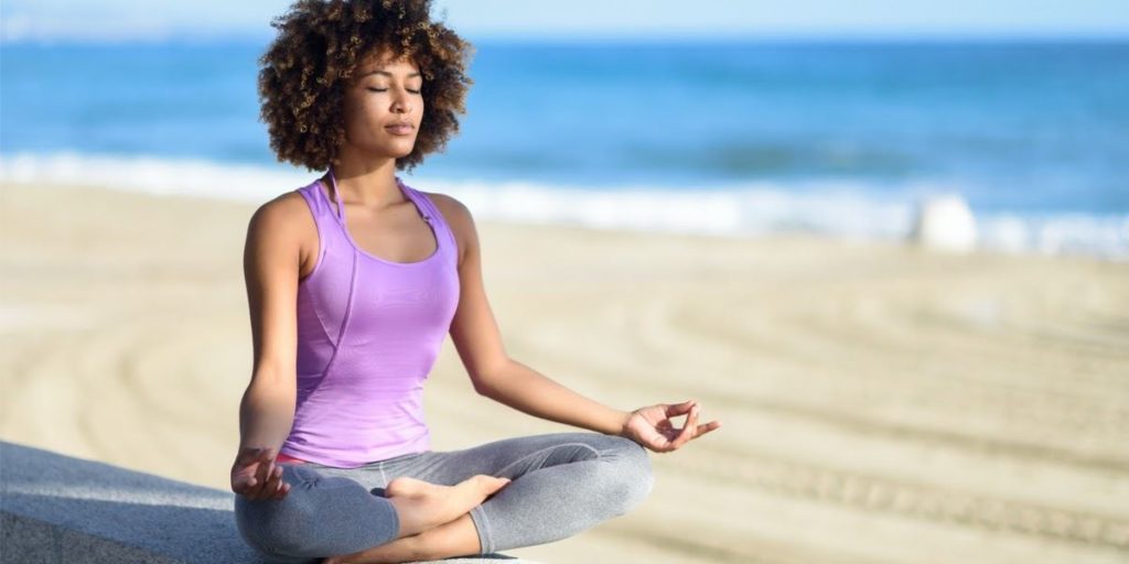 woman meditating on the beach