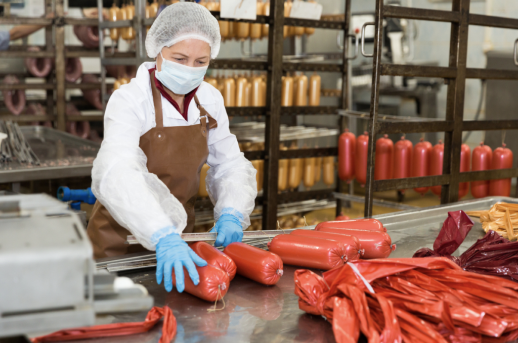 woman packaging processed meat and salami